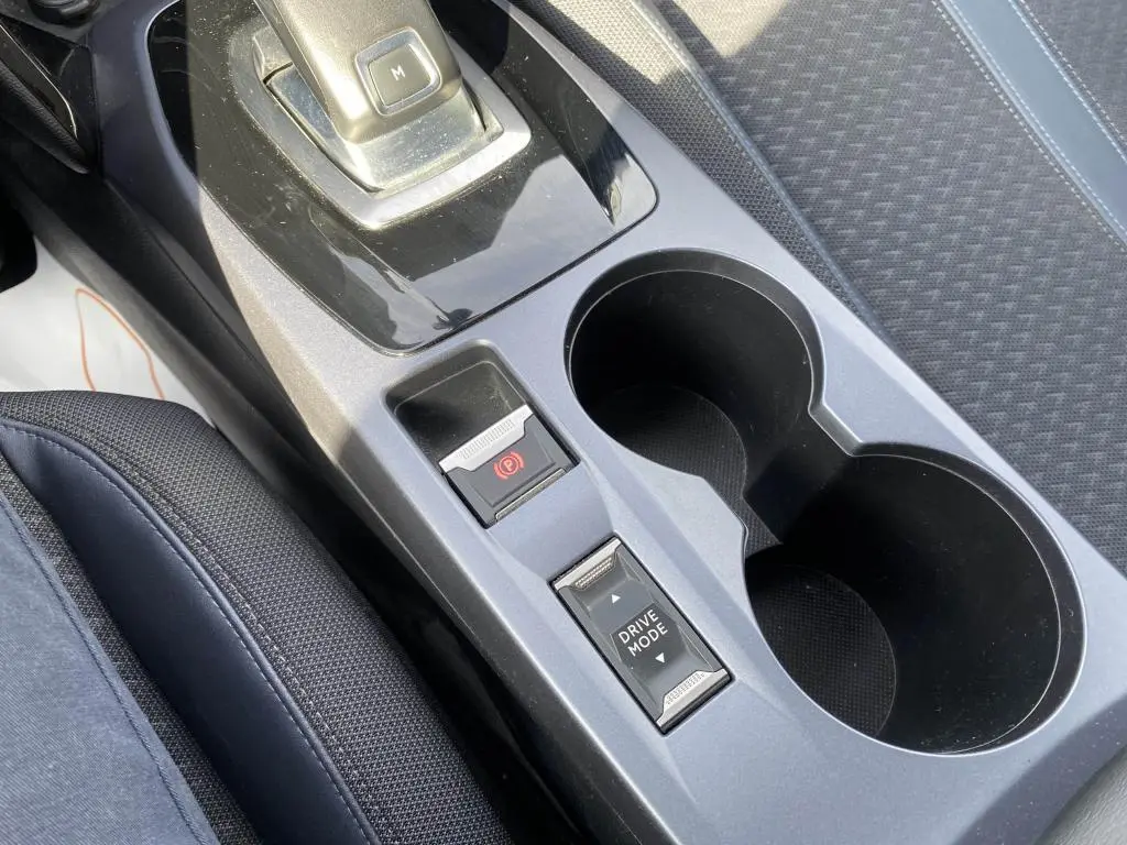 Gros plan sur la console centrale intérieure du Peugeot 2008 2020, montrant le frein de stationnement électrique et le sélecteur de mode de conduite.