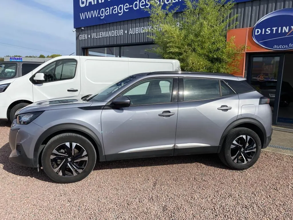 Peugeot 2008 gris clair vue de profil côté gauche, avec jantes noires et toit noir contrastant.