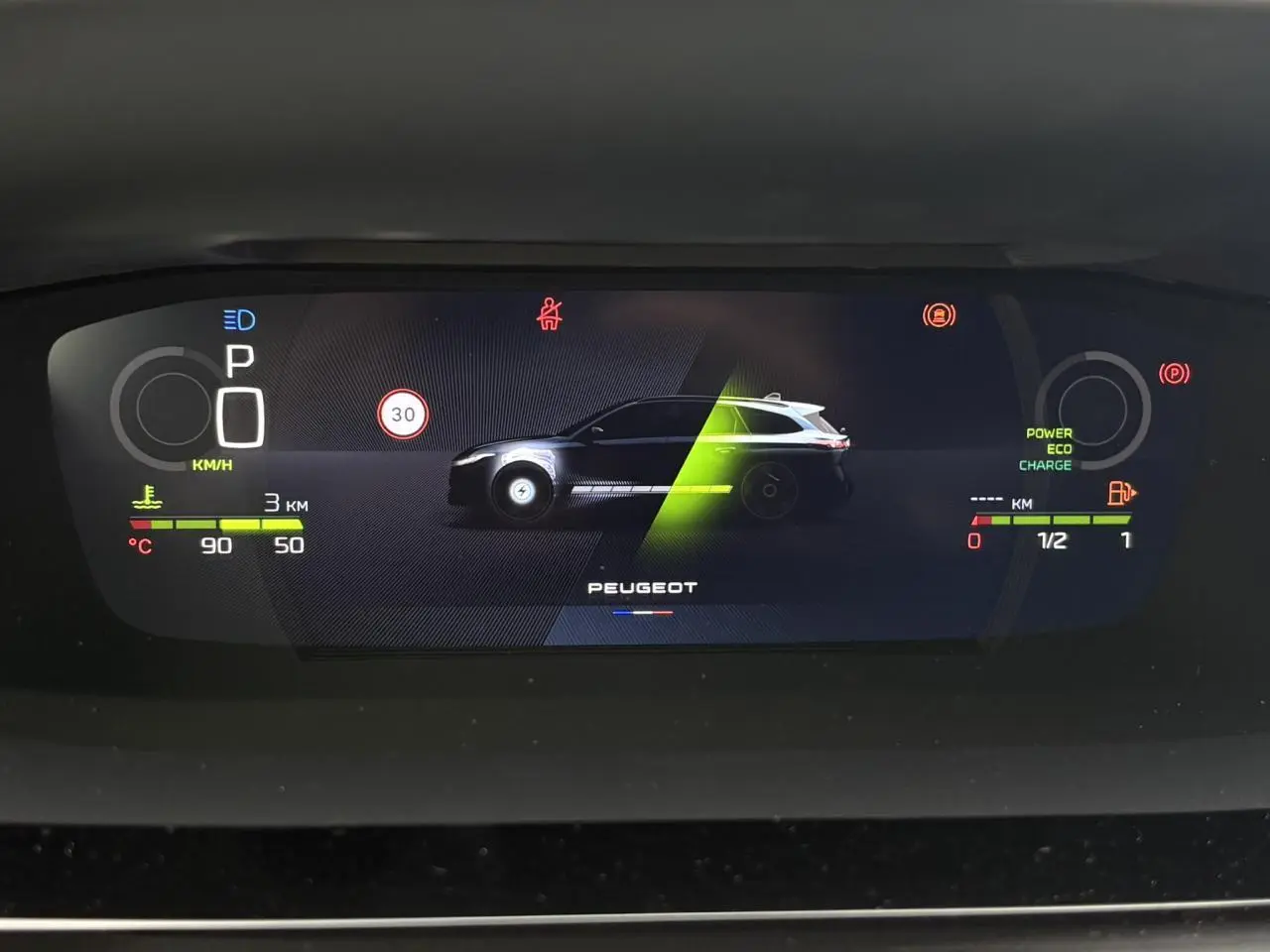Affichage numérique du tableau de bord de la Peugeot 308 SW Hybrid en vue frontale, avec indicateurs de vitesse et énergie.