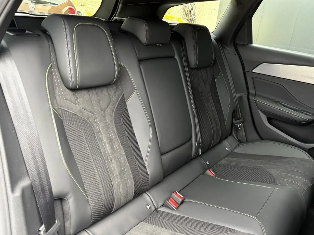Vue intérieure des sièges arrière en Alcantara noir avec surpiqûres vert Adamite de la Peugeot 308 SW 2026.