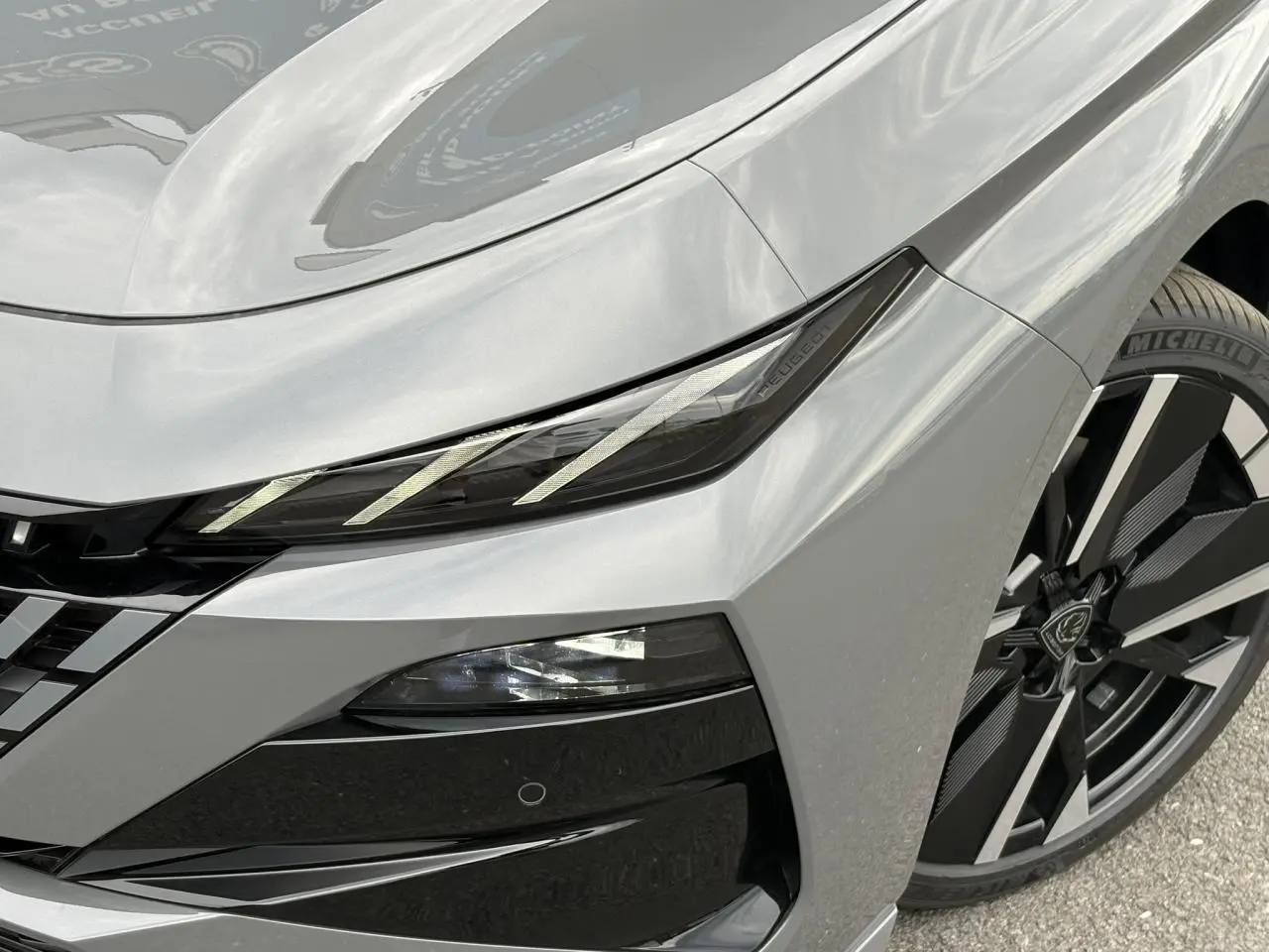 Gros plan sur l’avant droit gris Sélénium de la Peugeot 308 SW avec phares LED et jante alliage diamantée.