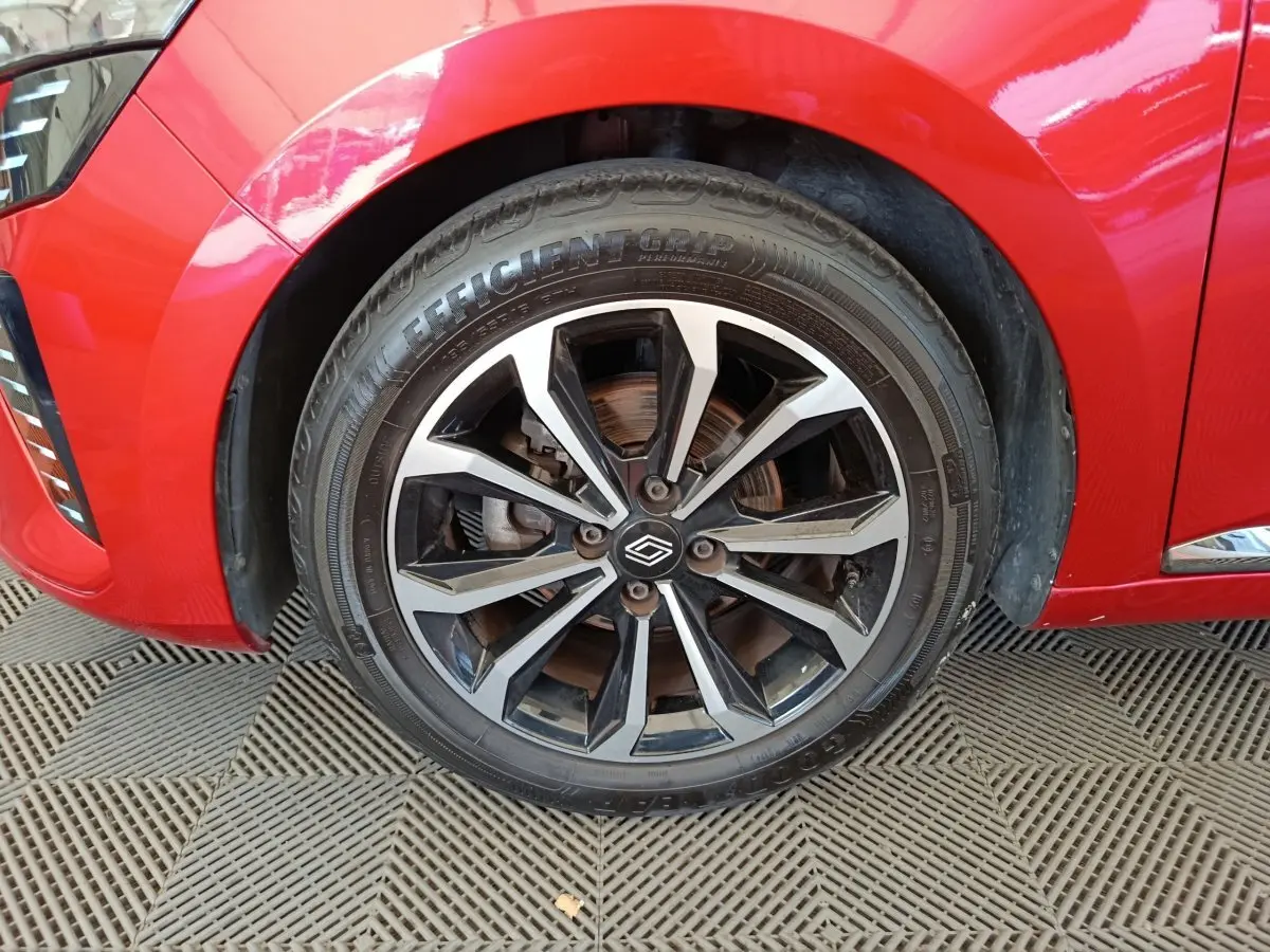 Gros plan sur la roue avant gauche de la Renault Clio rouge 2024, mettant en valeur la jante alliage noire et argent.