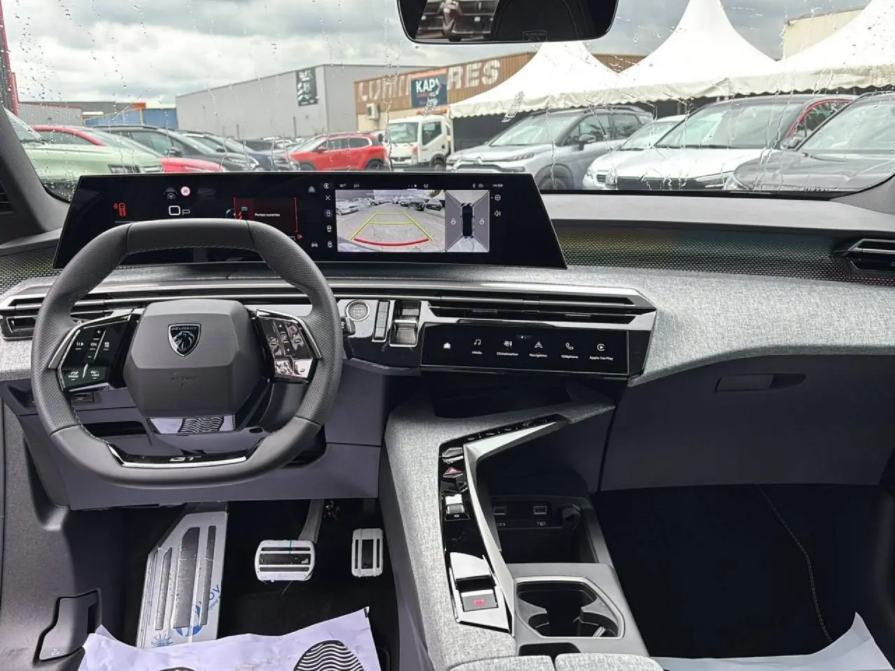 Vue intérieure du Peugeot 3008 Hybrid 2026 côté conducteur, avec tableau de bord numérique panoramique et volant compact noir.