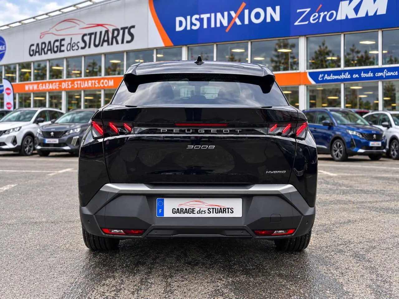 Vue arrière d’un Peugeot 3008 noir perla hybride, avec feux arrière LED en forme de griffes et hayon fermé.