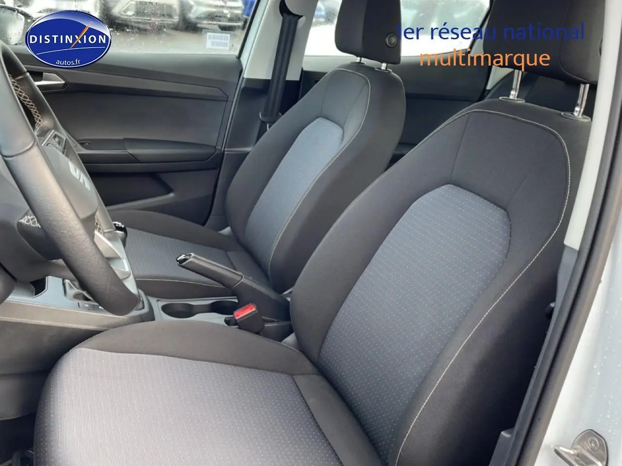 Vue intérieure côté conducteur montrant les sièges tissu gris de la SEAT Ibiza 1.0 TSI 95 Copa blanche Nevada.