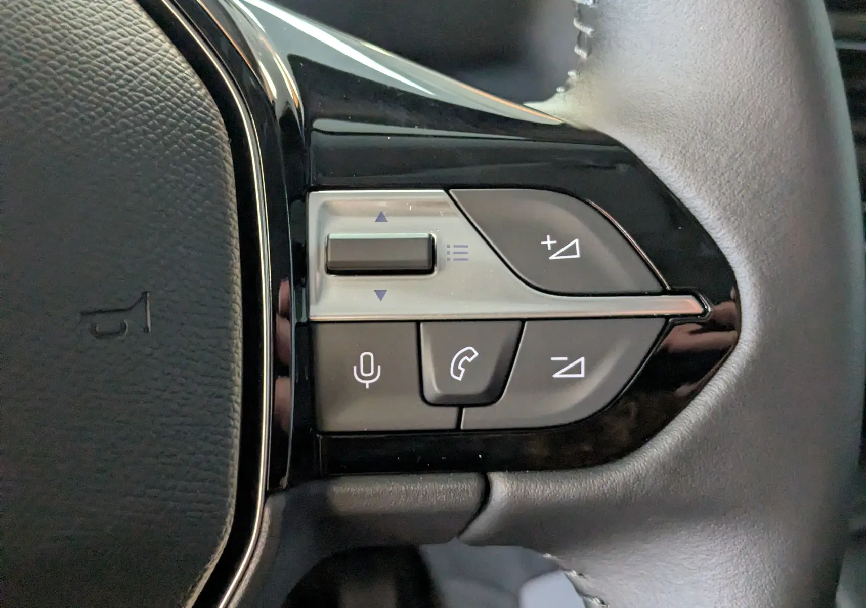 Gros plan sur les commandes multifonctions du volant du Peugeot Rifter gris Artense, version 2025 Allure Pack Style.