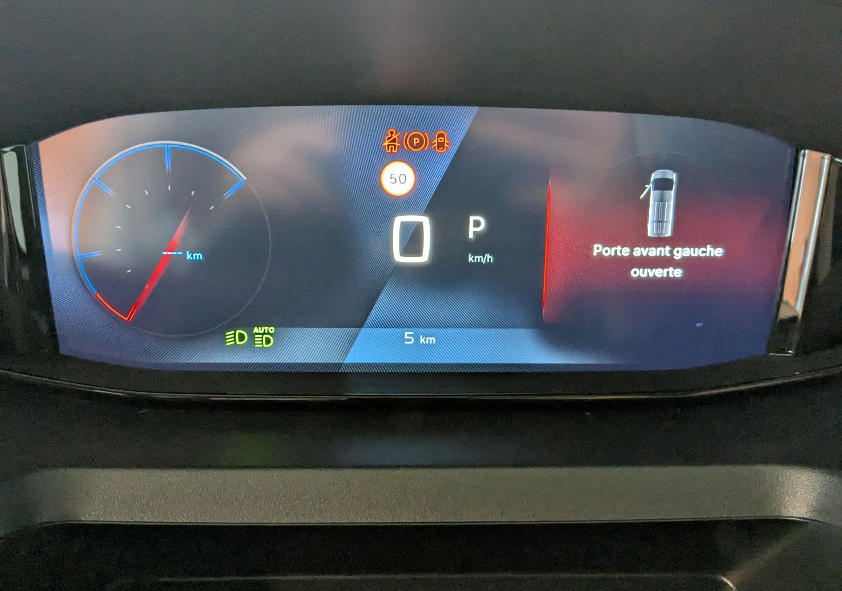 Tableau de bord numérique du Peugeot Rifter 2025 affichant la porte avant gauche ouverte et la vitesse à zéro km/h.