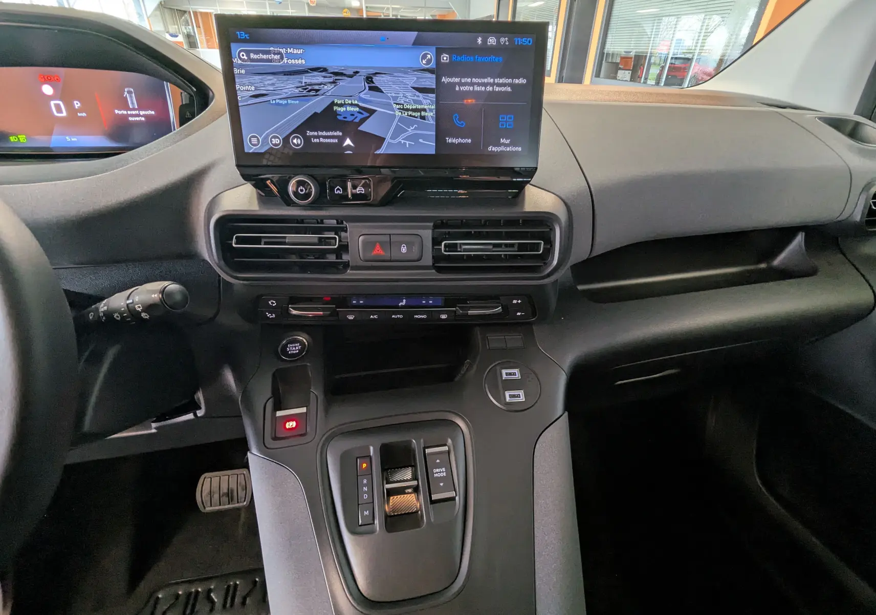 Vue intérieure du tableau de bord du Peugeot Rifter 2025 avec écran tactile central et commandes de boîte automatique.