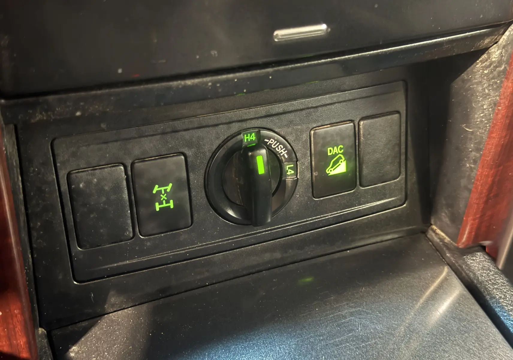 Détail du tableau de bord du Toyota Land Cruiser 2015 montrant les commandes 4x4 et DAC éclairées en vert.