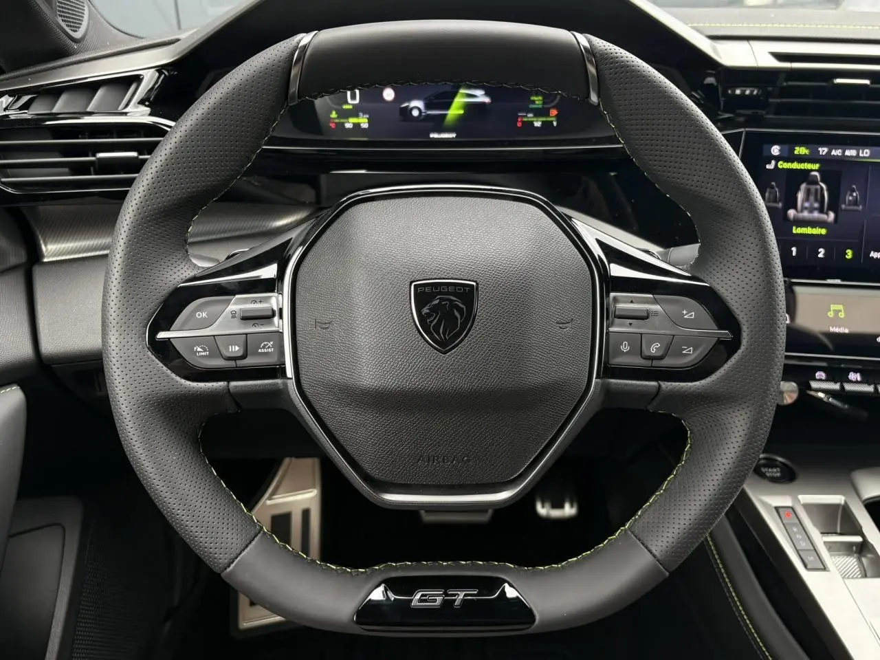Vue rapprochée du volant compact GT en cuir noir avec surpiqûres vert Adamite du Peugeot 308 SW Hybrid 2026.