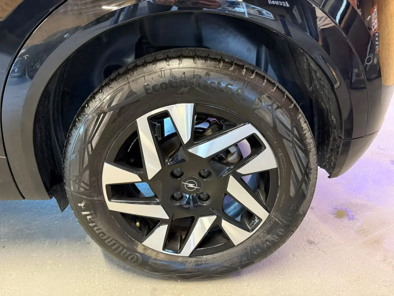 Gros plan sur la roue avant droite noire et argentée du SUV Opel Mokka noir avec jante alliage 17 pouces diamantée.