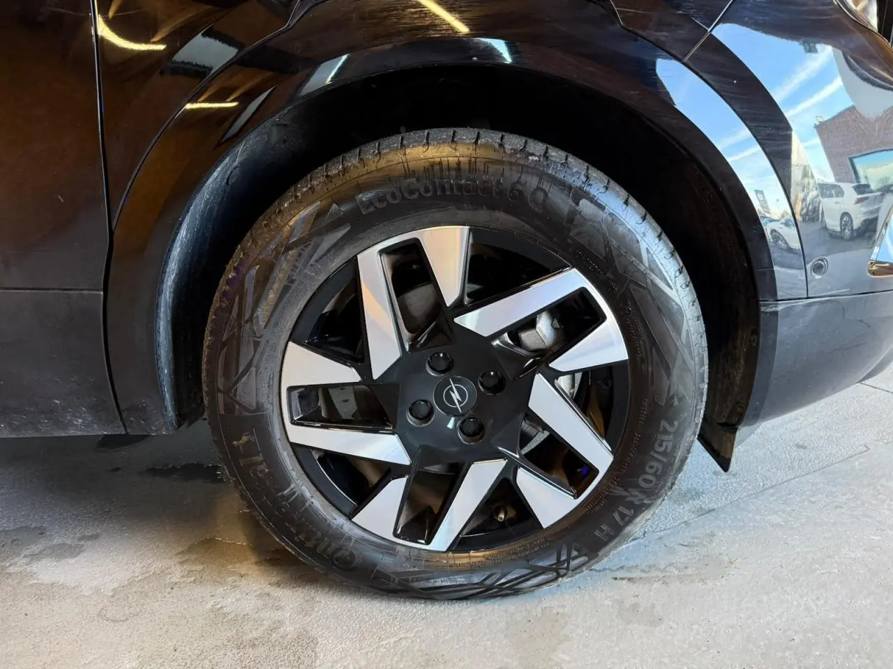 Gros plan sur la roue avant droite noire d’un Opel Mokka 2025 avec jante alliage diamantée bicolore.