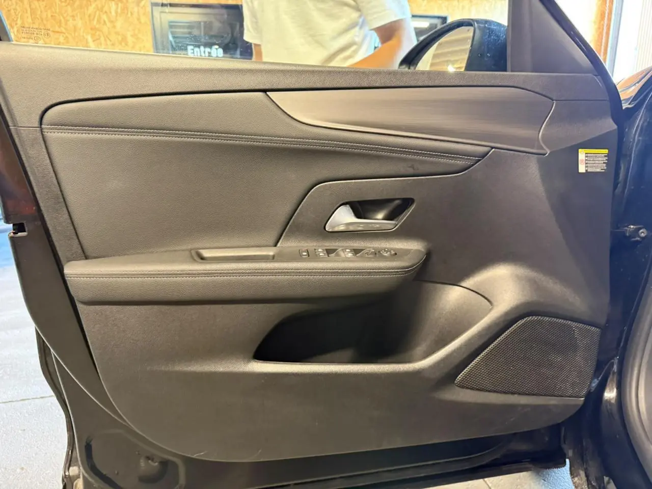 Vue intérieure de la porte avant gauche noire de l’Opel Mokka 2025 avec commandes électriques et haut-parleur intégré.