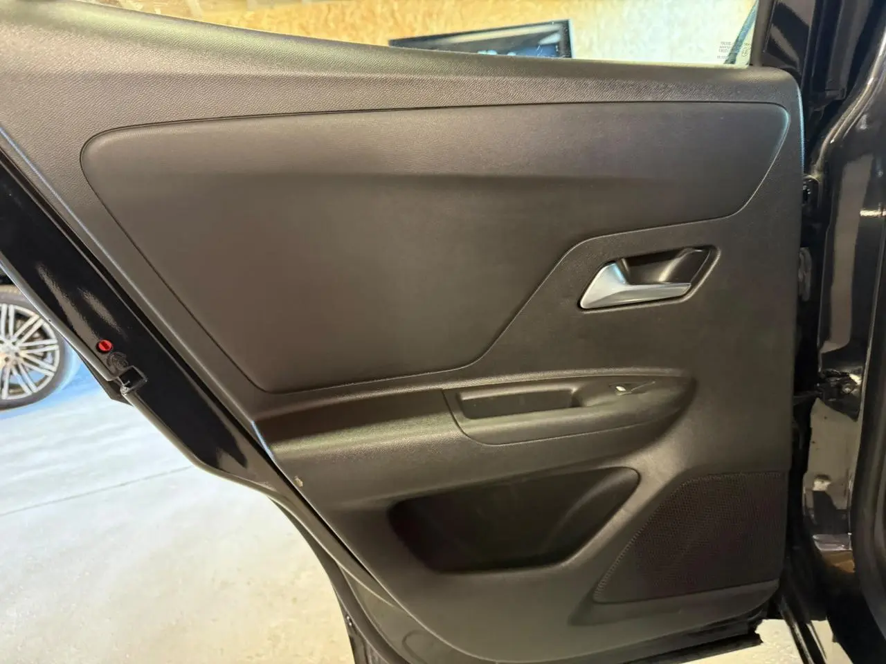 Vue intérieure de la porte arrière droite noire de l’Opel Mokka 2025, avec poignée et haut-parleur intégrés.