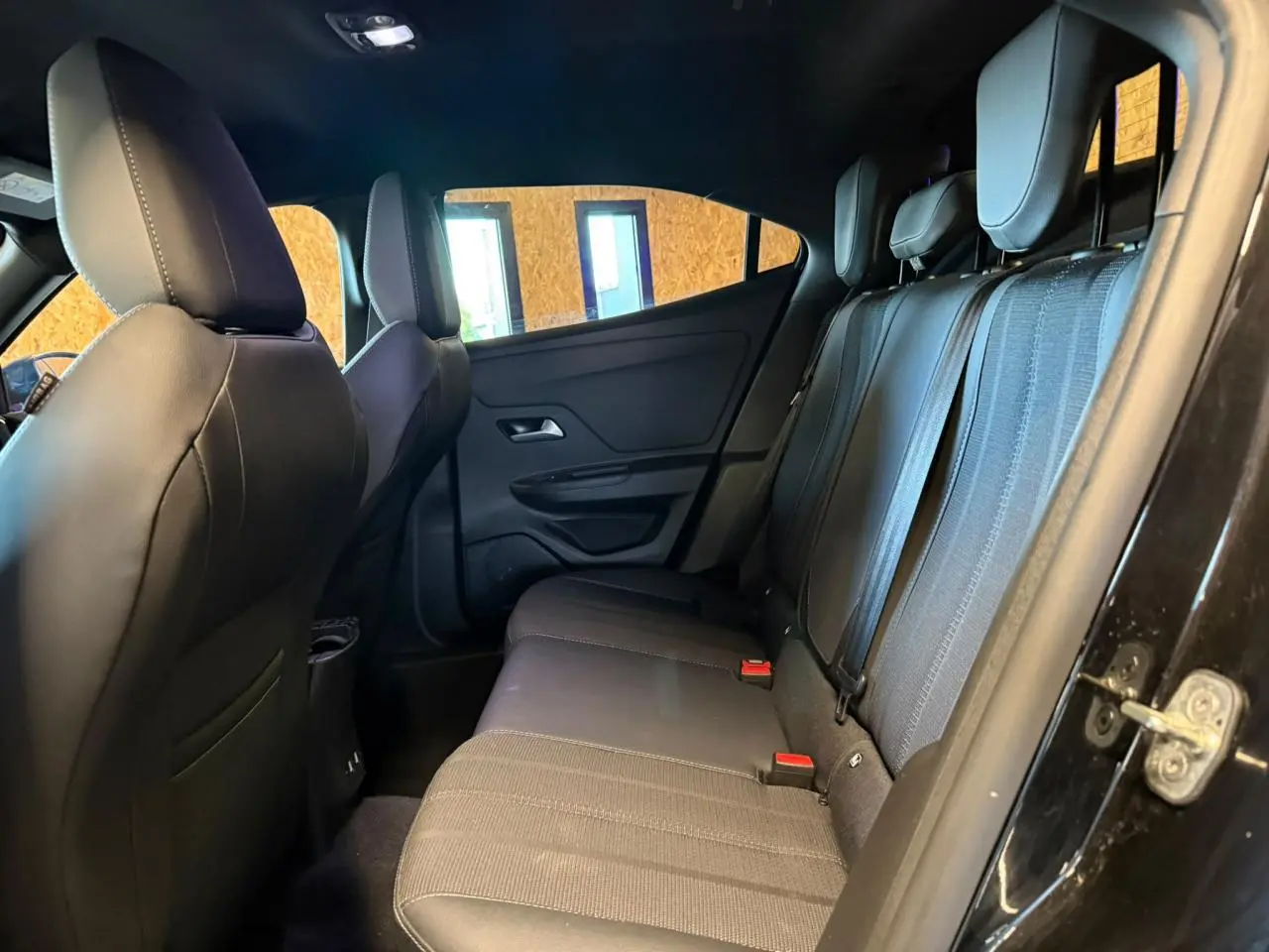 Vue intérieure arrière côté droit de l’Opel Mokka 2025, montrant la banquette mixte tissu noir et gris avec appuie-têtes réglables.