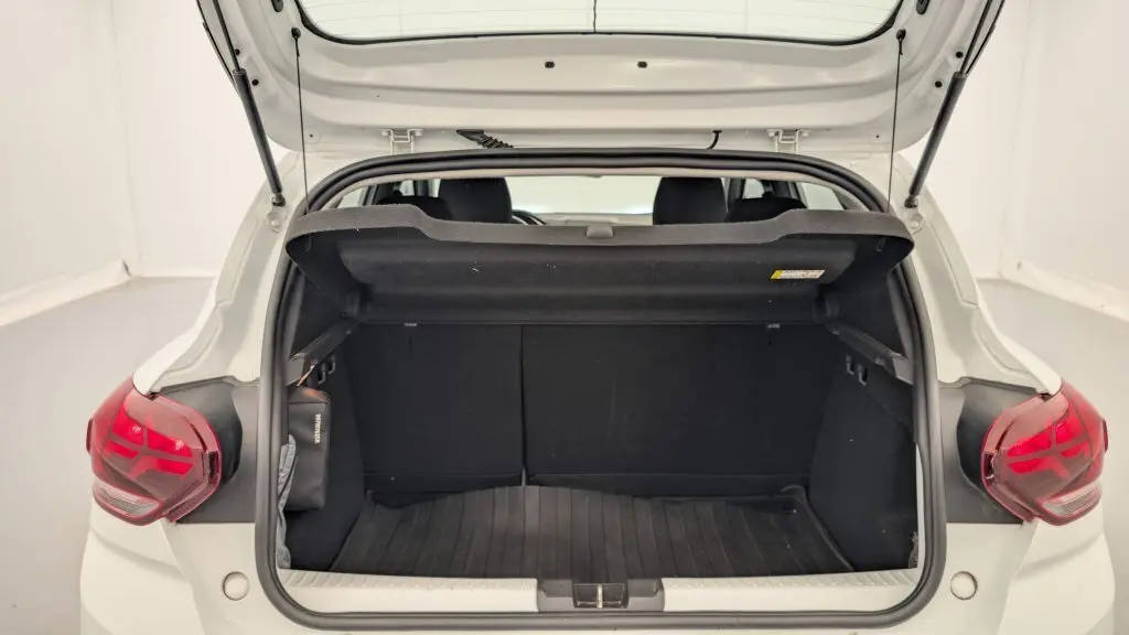 Coffre ouvert vu de l'arrière d'une Dacia Sandero blanc glacier 2022 avec feux arrière à signature lumineuse en Y.