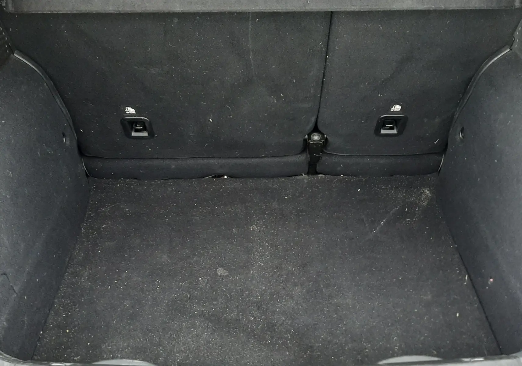 Coffre ouvert de FIAT 500X rouge 2016, montrant l'espace de chargement avec revêtement noir et sièges arrière rabattus.