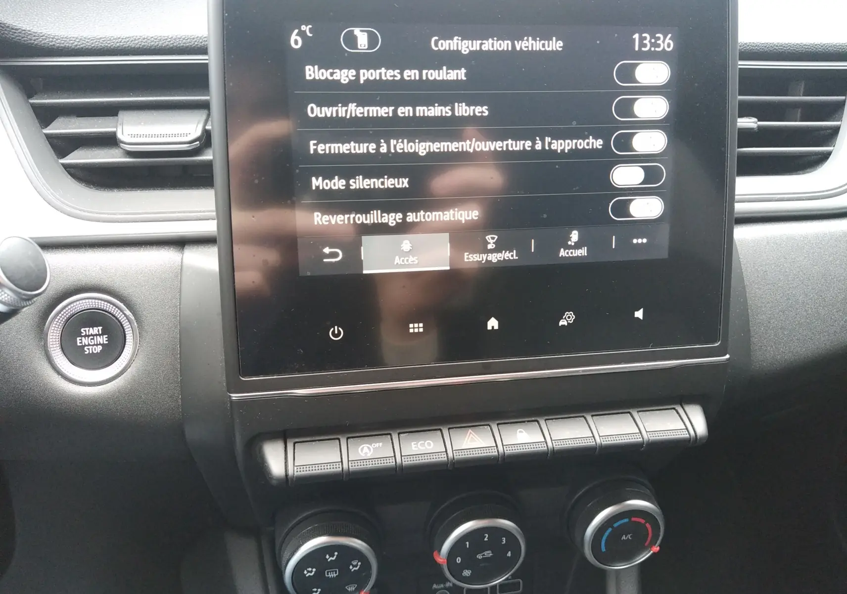 Tableau de bord du Renault Captur 2021 noir, vue centrée sur l'écran tactile et les commandes de climatisation.