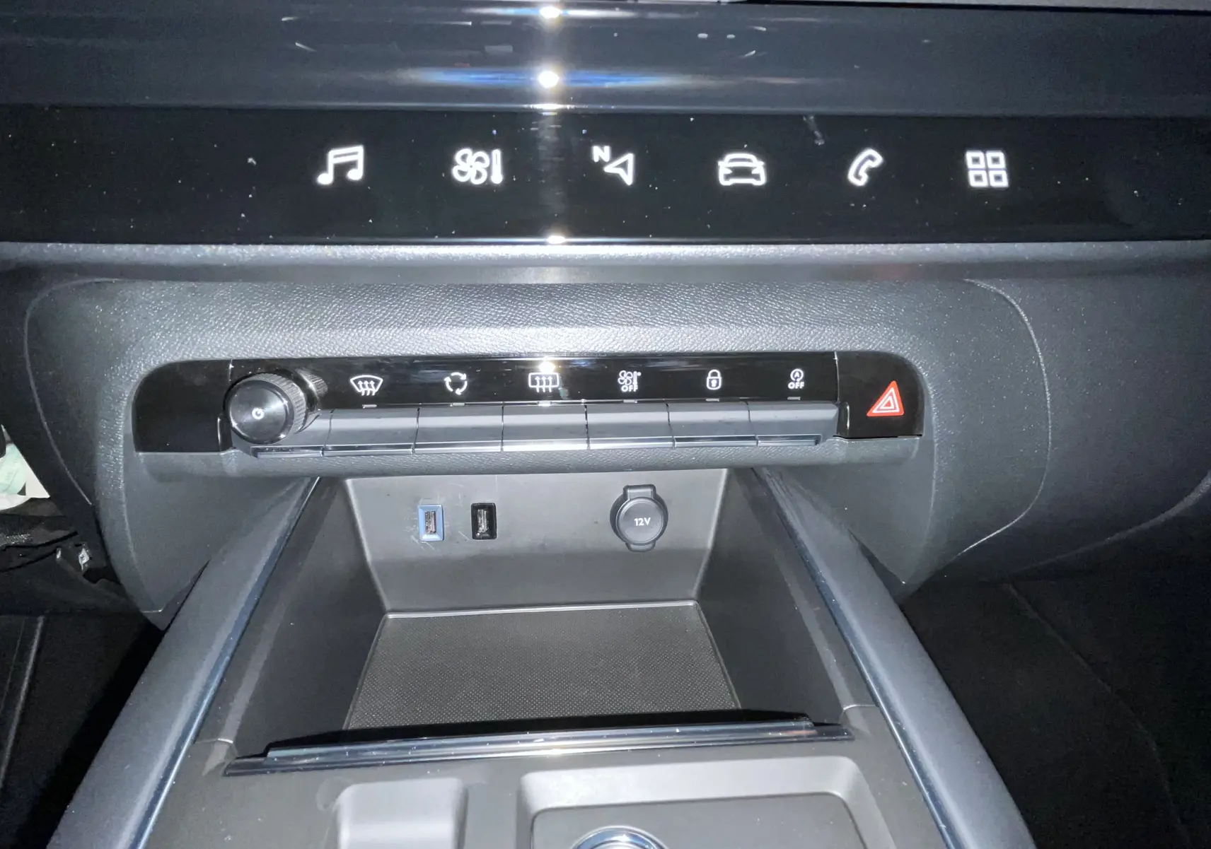 Vue rapprochée de la console centrale noire du Citroën C5 Aircross 2024 avec commandes tactiles et prises USB visibles.