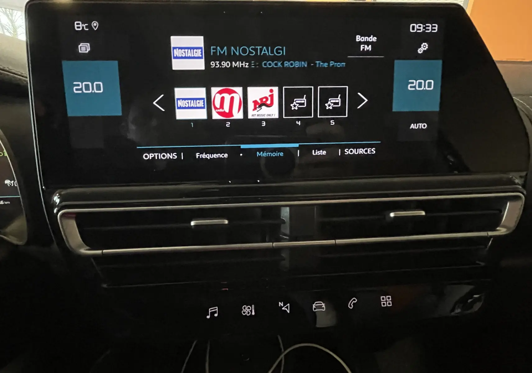 Écran tactile central du tableau de bord du Citroën C5 Aircross 2024 affichant la radio FM et la climatisation à 20°C.