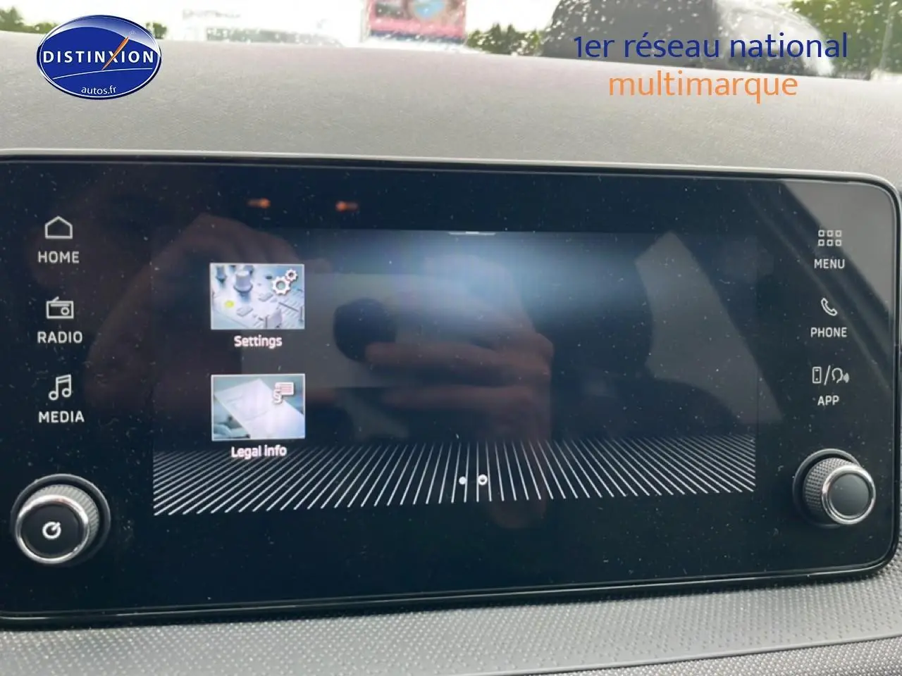Écran tactile central de la Skoda Fabia blanche 2025, affichant le menu des réglages et infos légales.