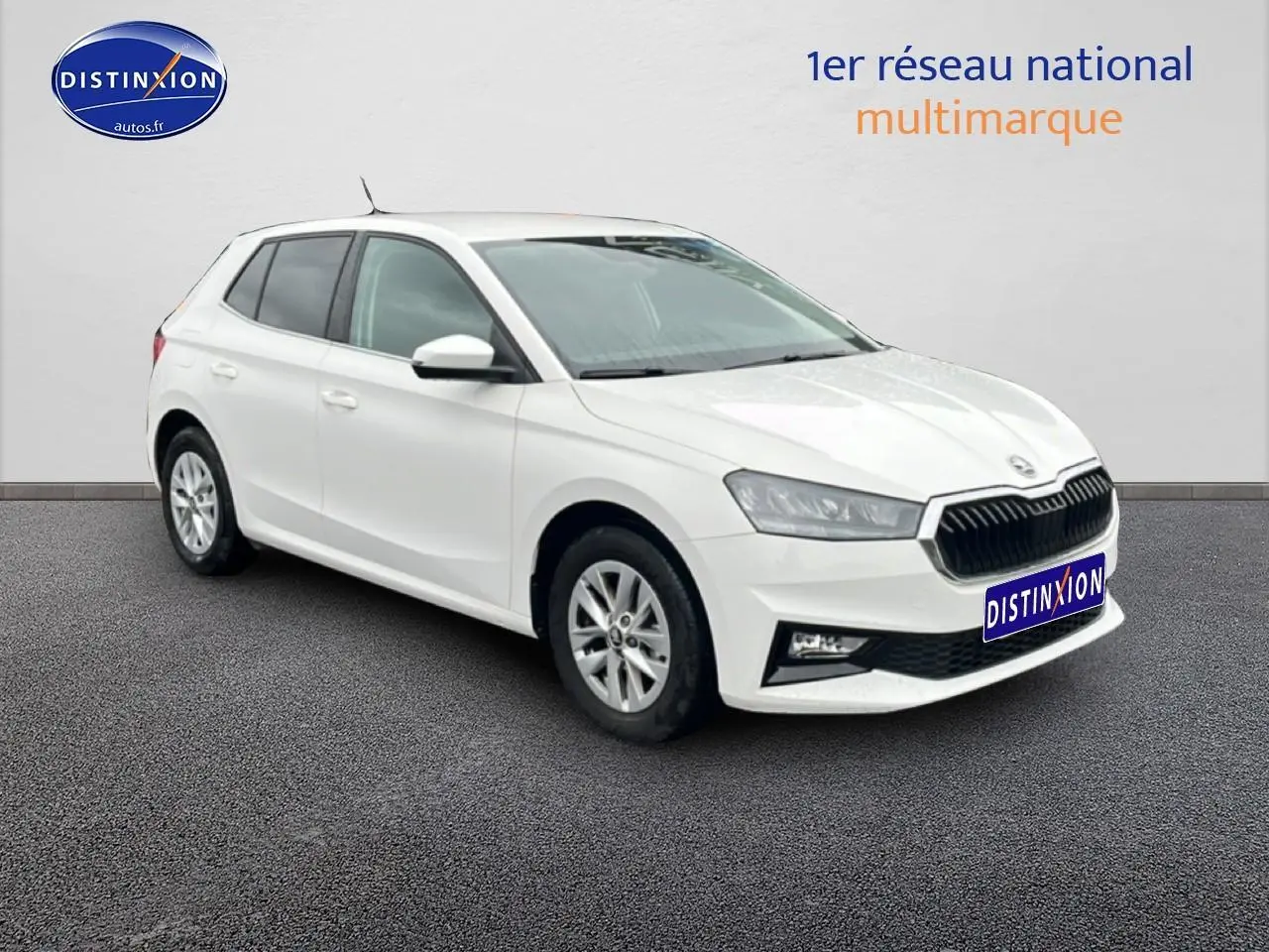 Vue 3/4 avant droite d'une Skoda Fabia blanche avec jantes alu et calandre noire distinctive.