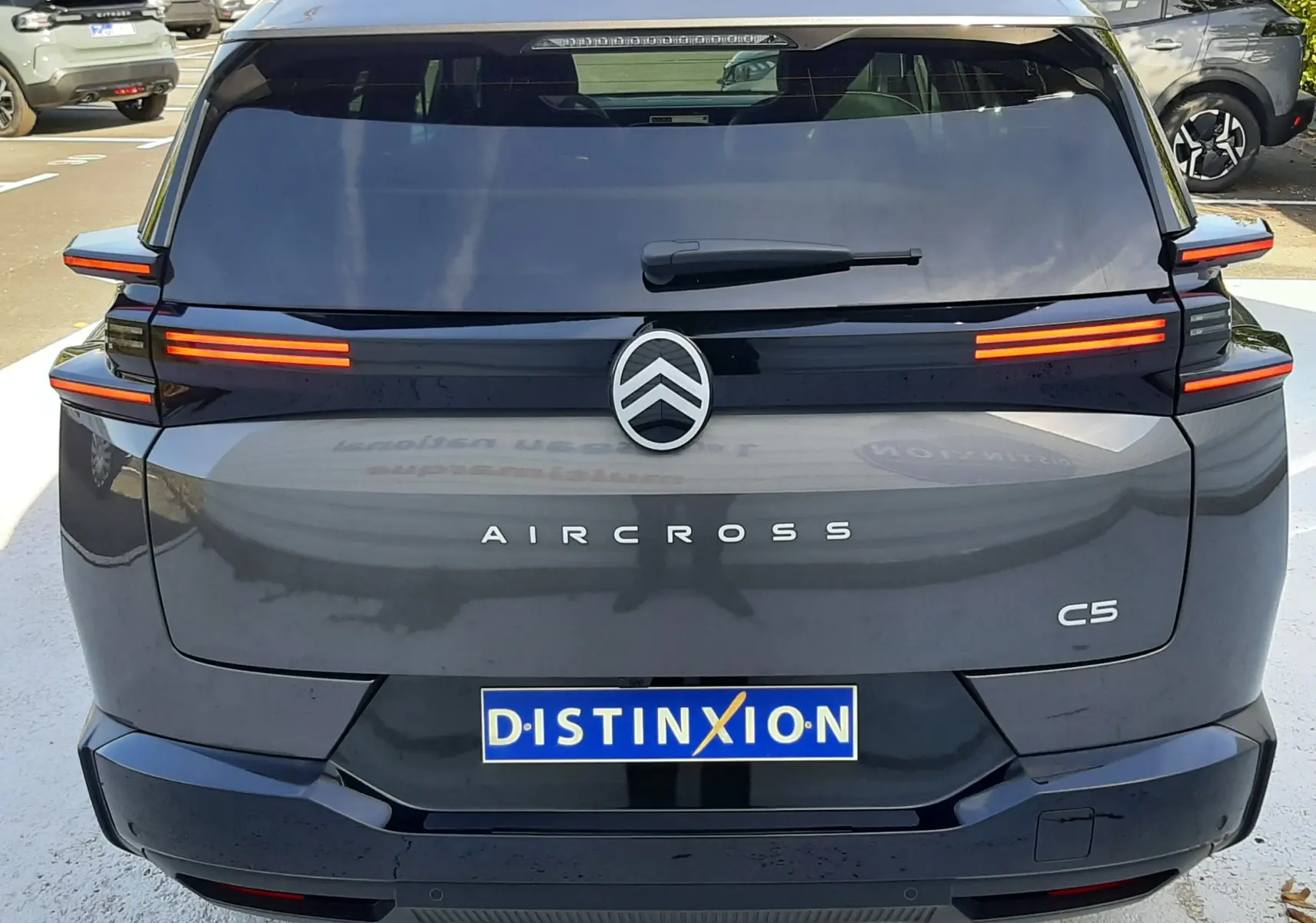 Vue arrière du Citroën C5 Aircross gris platinium 2026 avec feux LED horizontaux et logo centré sur hayon noir brillant.