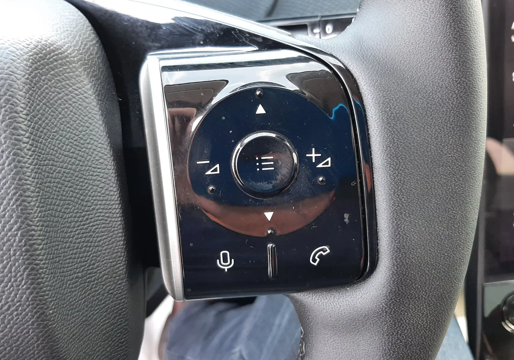 Gros plan sur les commandes noires du volant du Citroën C5 Aircross hybride 2026, avec boutons de volume et téléphone.