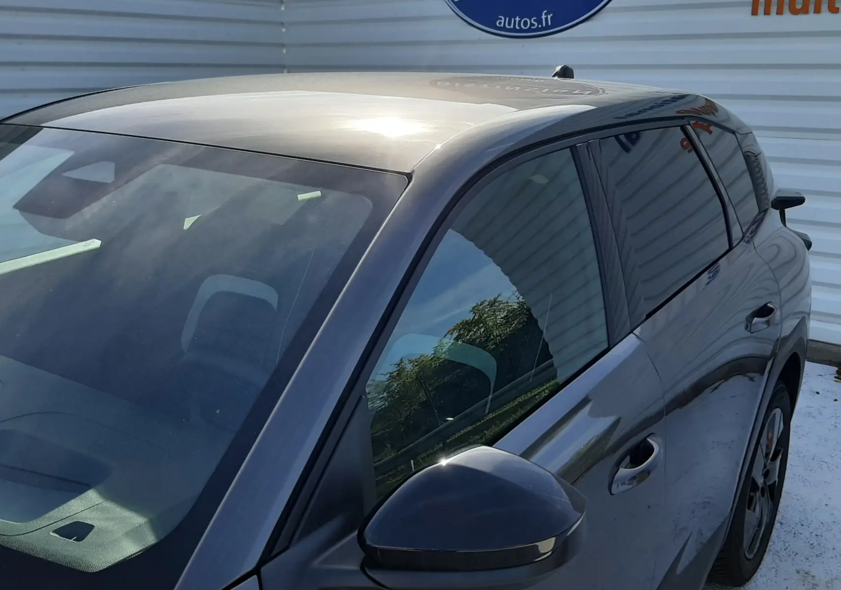 Vue 3/4 avant droit du Citroën C5 Aircross hybride gris platinium avec rétroviseur et vitres teintées visibles.