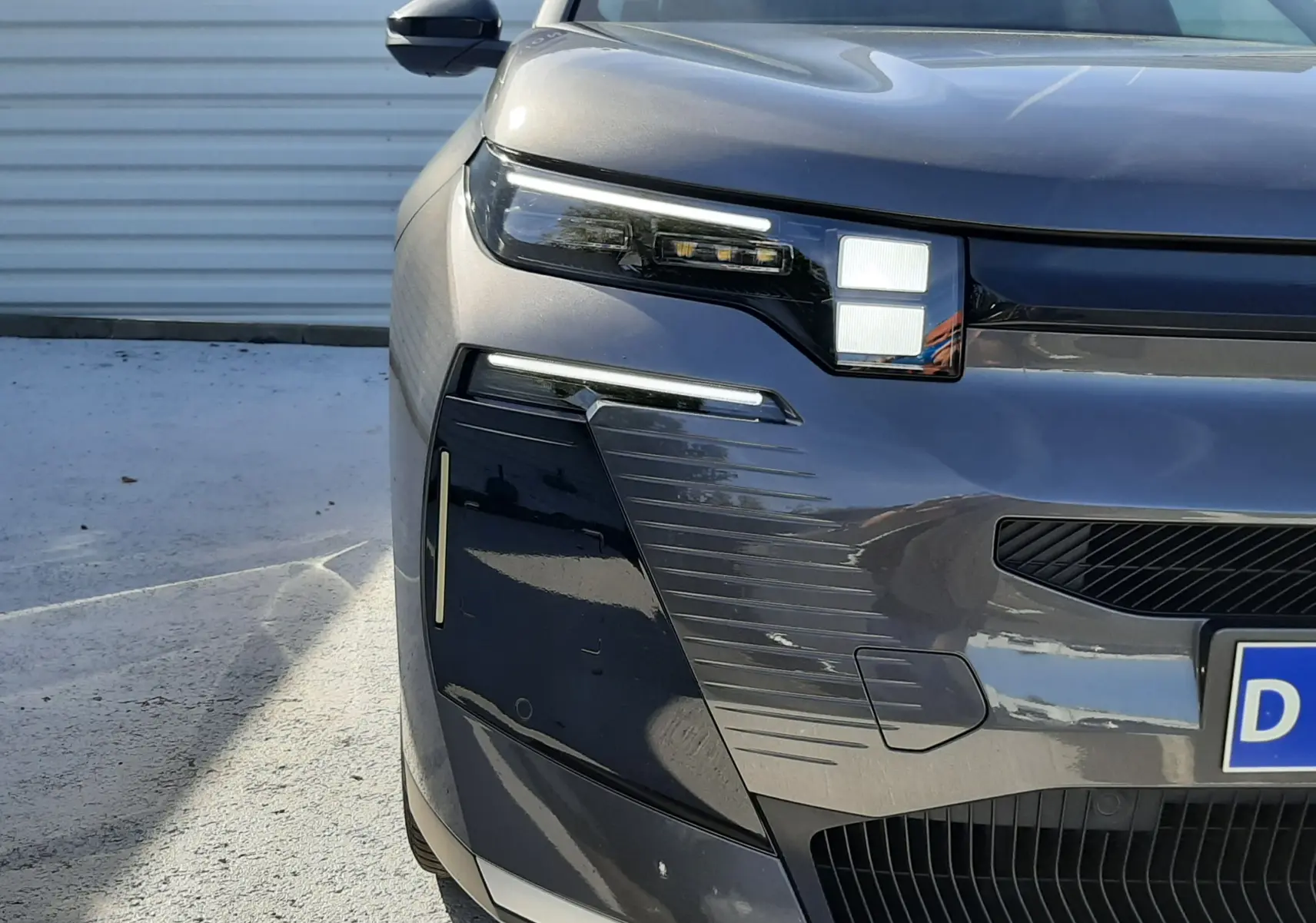 Vue avant rapprochée du Citroën C5 Aircross hybride gris platinium, mettant en valeur ses phares LED distinctifs.