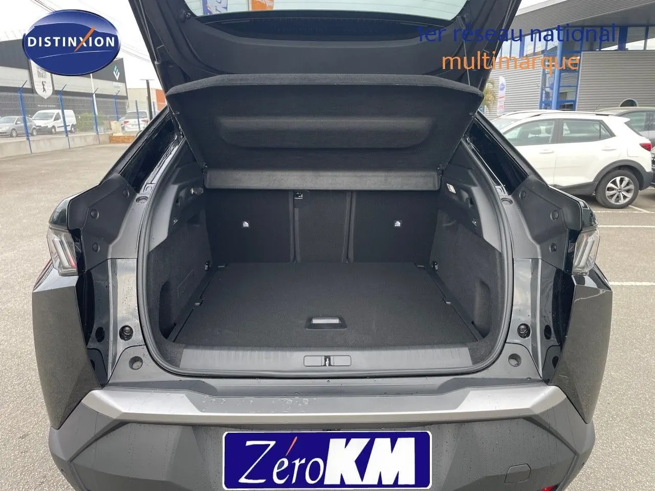 Coffre ouvert vue arrière d'un Peugeot 3008 HYBRID noir perle métal, montrant un espace de chargement spacieux et propre.