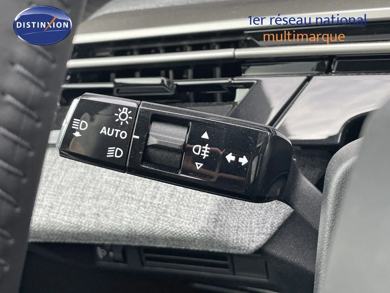 Gros plan sur la commande des phares et clignotants du Peugeot 3008 Hybrid noir perle métal, intérieur tissu gris.