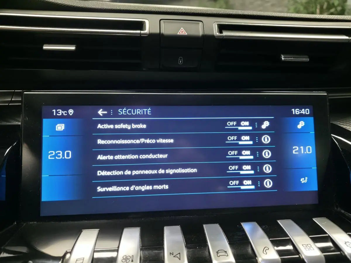 Écran tactile central intérieur de Peugeot 508 bleu affichant les réglages de sécurité du véhicule.