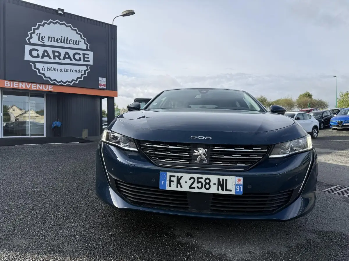 Vue frontale d'une Peugeot 508 bleue métallisée avec calandre chromée et plaque d'immatriculation française.