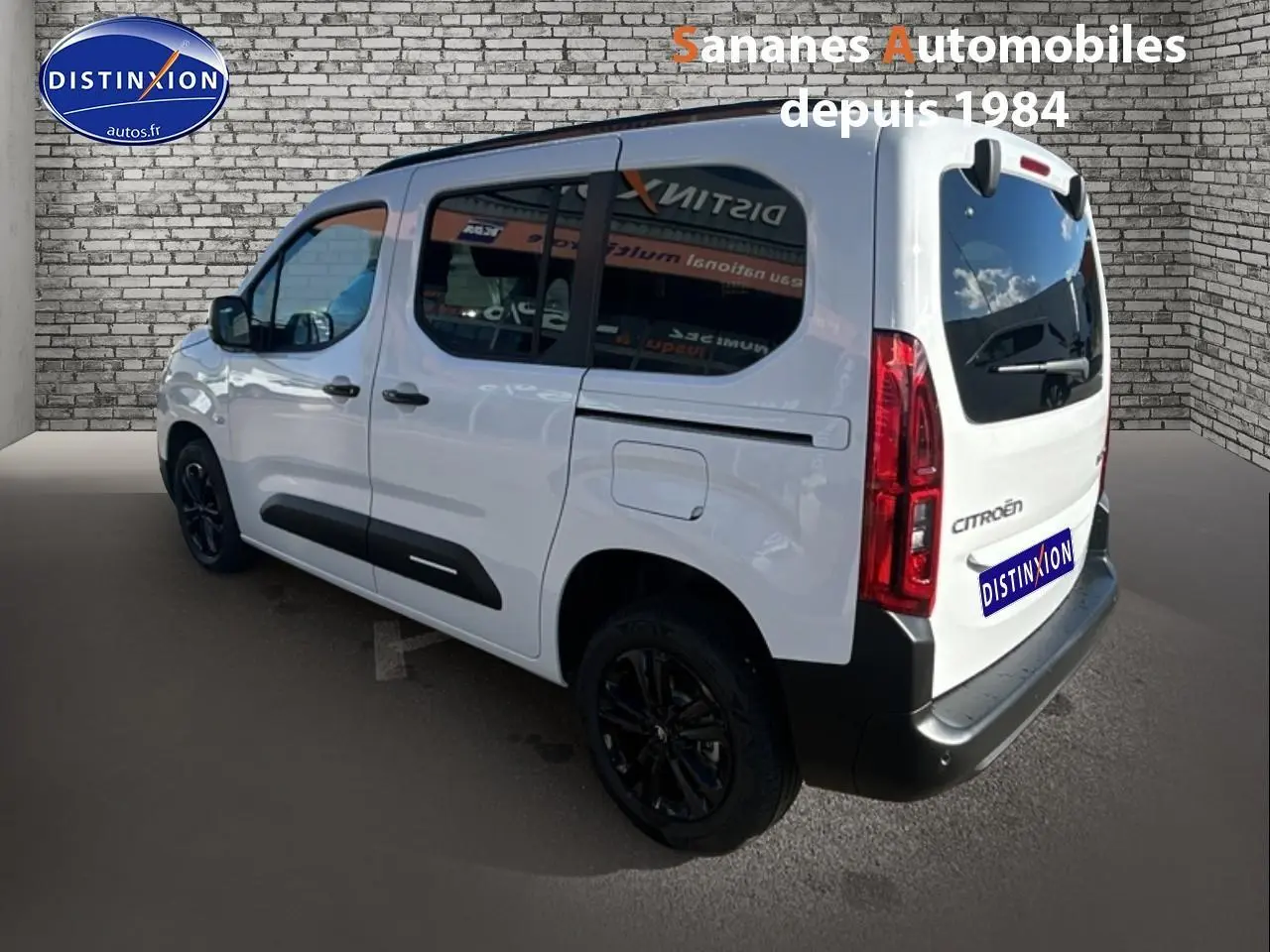 Vue 3/4 arrière droite d'un Citroën Berlingo blanc avec vitres arrière surteintées et jantes alliage noires.