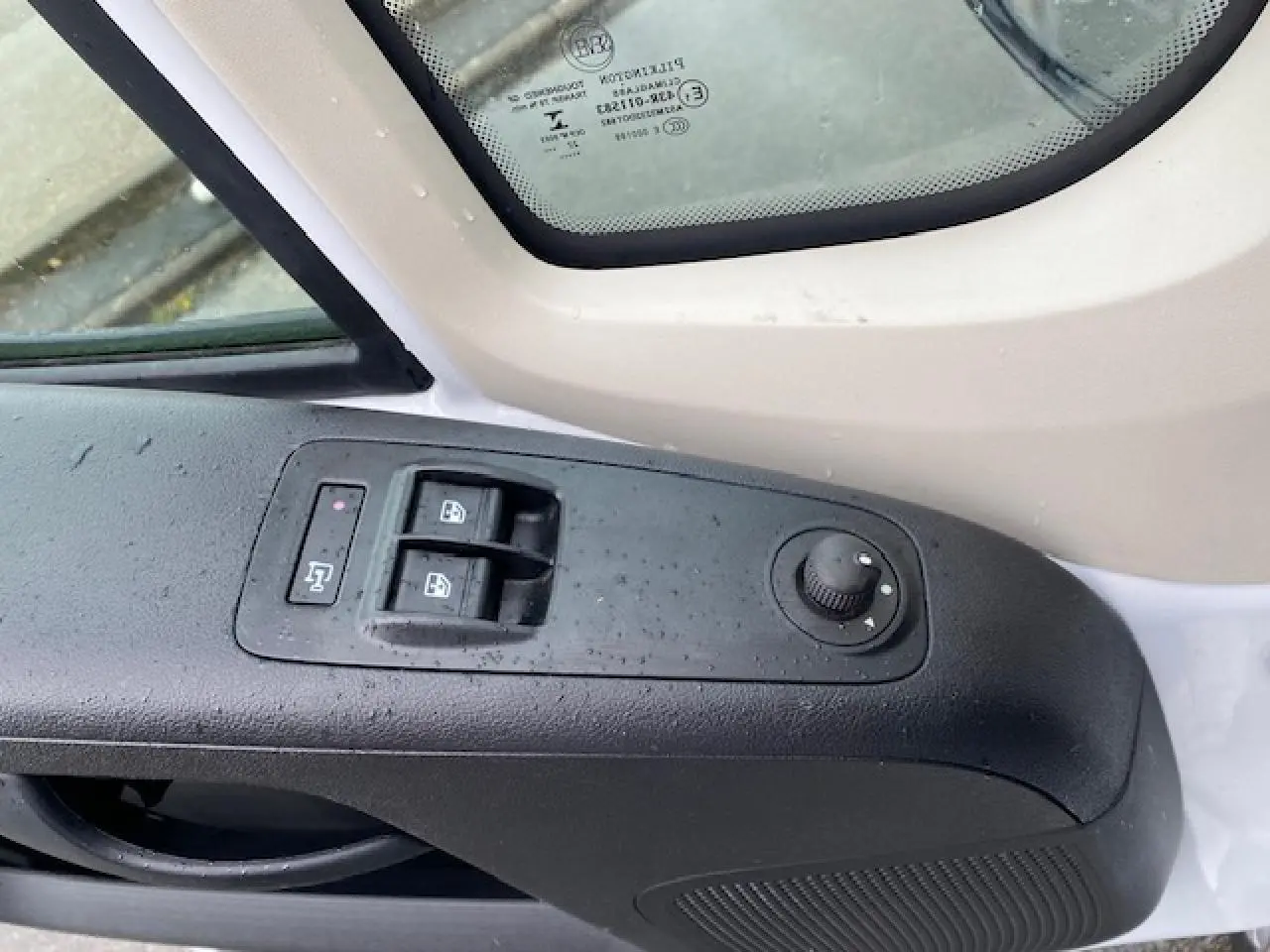 Détail de la commande des vitres et rétroviseurs côté conducteur du fourgon blanc Opel Movano 2023.