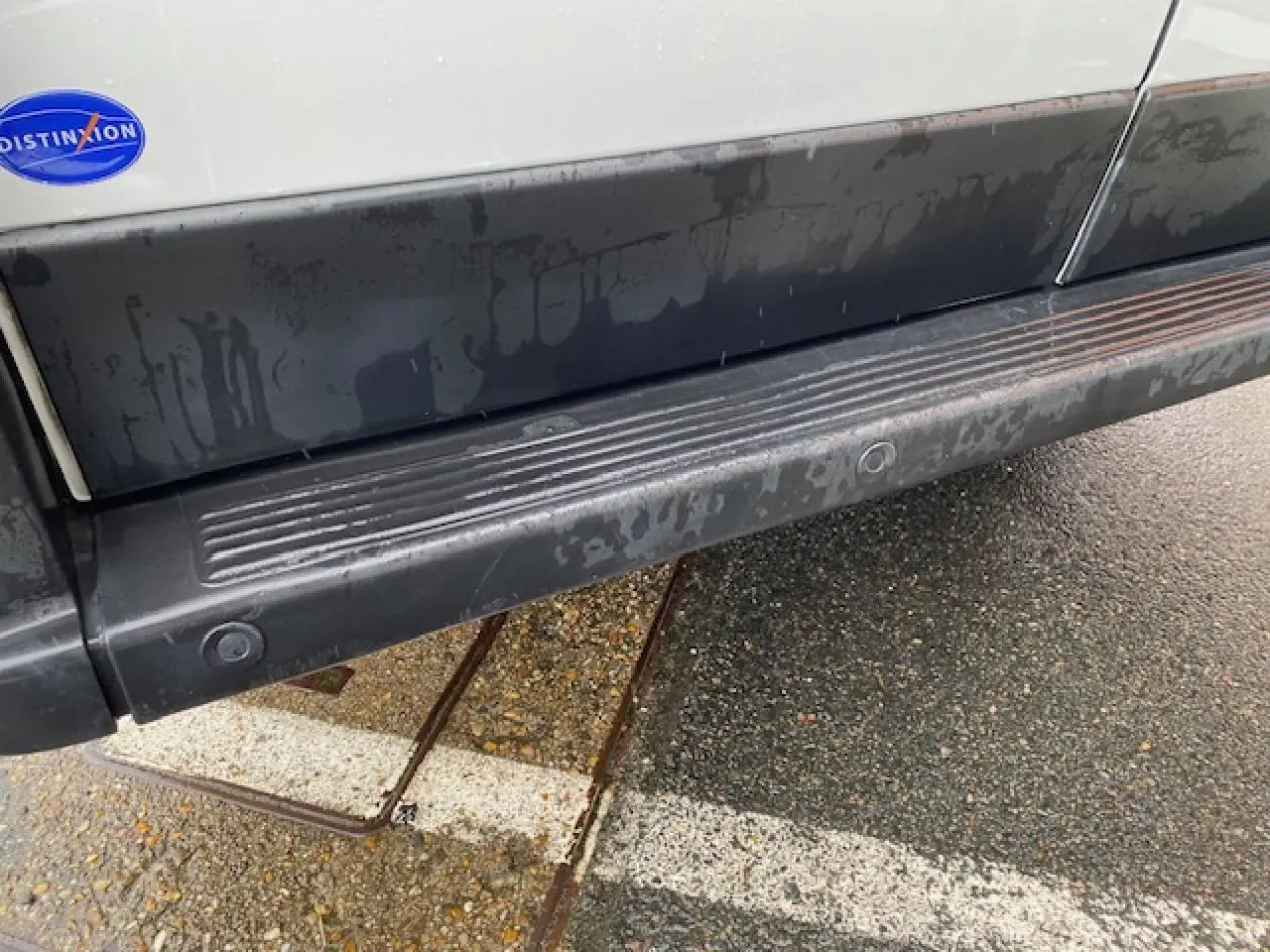 Gros plan sur la partie basse côté droit du fourgon blanc Opel Movano 2023 avec marchepied et porte latérale coulissante.