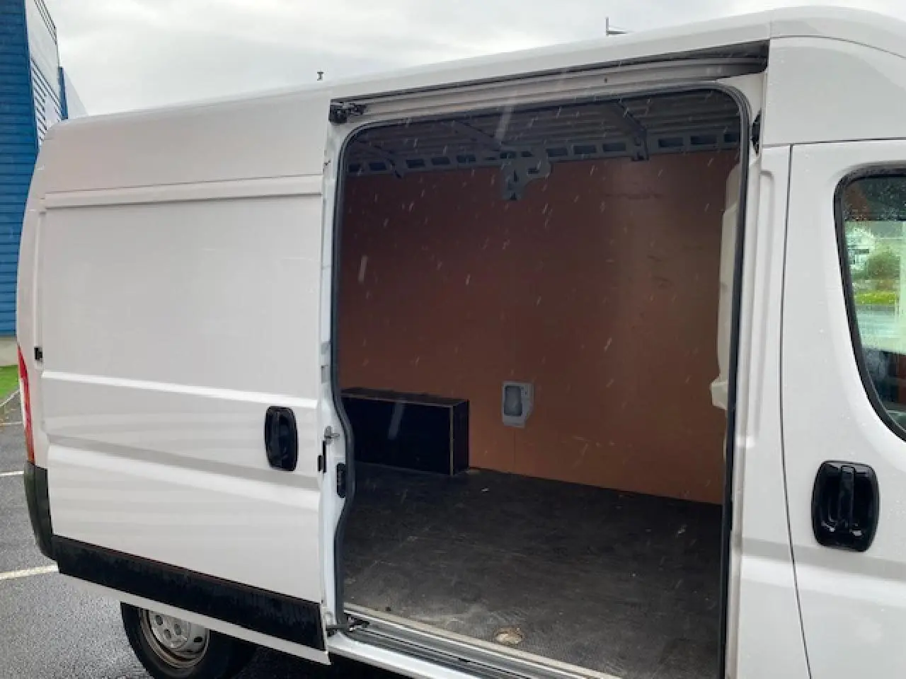 Vue latérale droite d'un Opel Movano Fourgon blanc 2023 avec porte coulissante ouverte montrant l'intérieur vide.