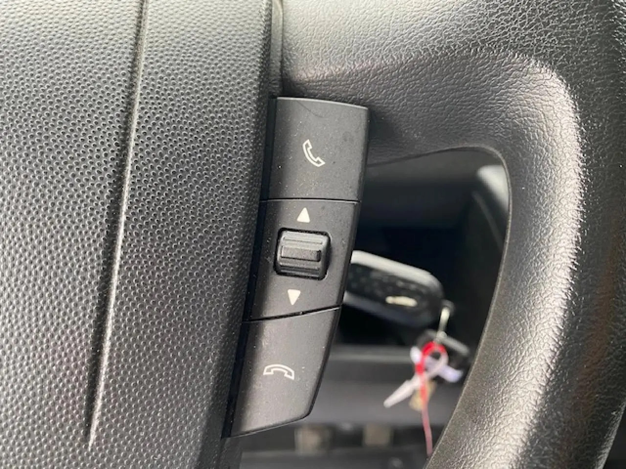 Détail des commandes Bluetooth sur le volant noir d’un Opel Movano Fourgon 2023, vue rapprochée.