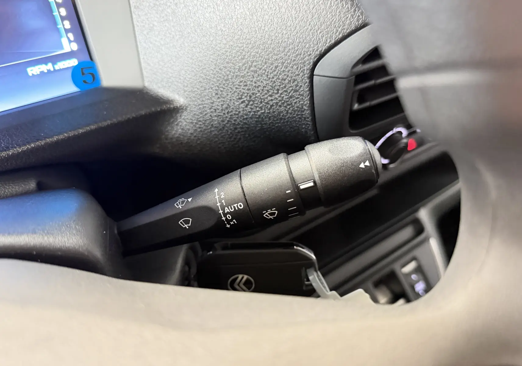 Gros plan sur la commande d’essuie-glace noire dans l’habitacle du Citroën Jumpy Cabine Approfondie gris titane.