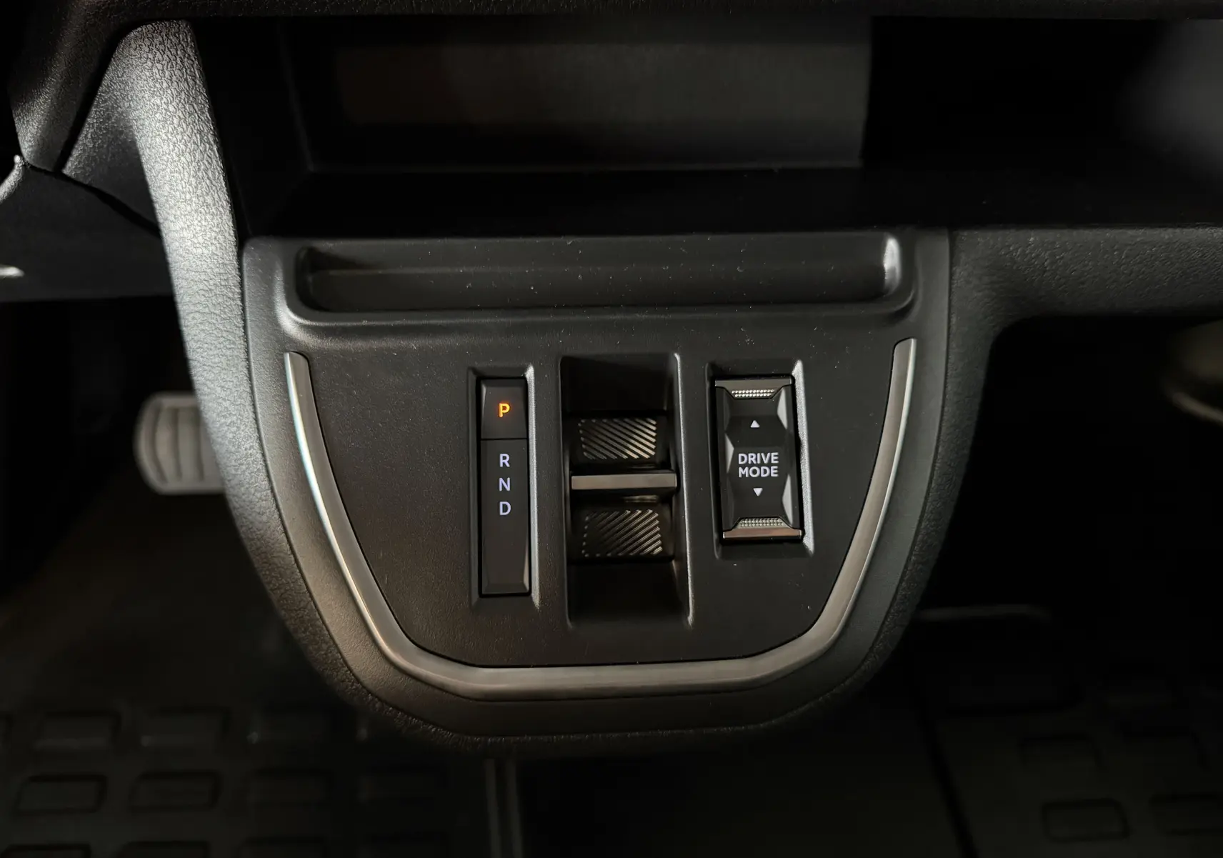 Vue rapprochée de la console centrale noire du Citroën Jumpy gris titane, avec sélecteur de boîte auto et bouton Drive Mode.