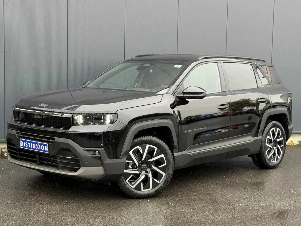 Jeep Compass Hybrid 145 e-DSC6 Summit noir Vulcano, vue 3/4 avant avec jantes alliage 19 pouces et barres de toit.