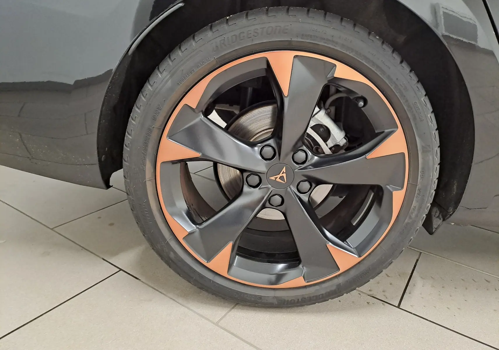 Gros plan sur la jante alliage 18'' cuivrée et noire du CUPRA LEON ST 1.5 eTSI 150 DSG7 Noir Minuit, côté arrière droit.