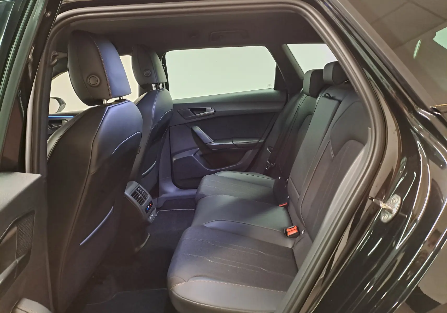 Vue intérieure côté gauche des sièges arrière en cuir noir du CUPRA LEON ST 1.5 eTSI 150 DSG7, ambiance sobre et moderne.