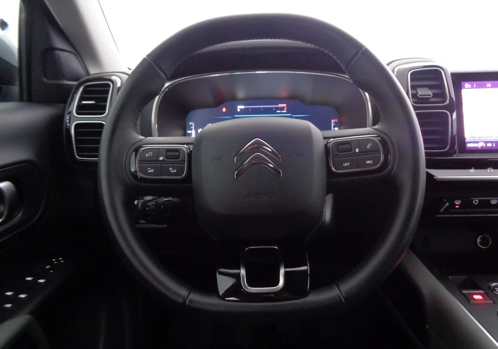 Vue centrée sur le volant noir du Citroën C5 Aircross 2021 avec commandes intégrées et tableau de bord numérique.