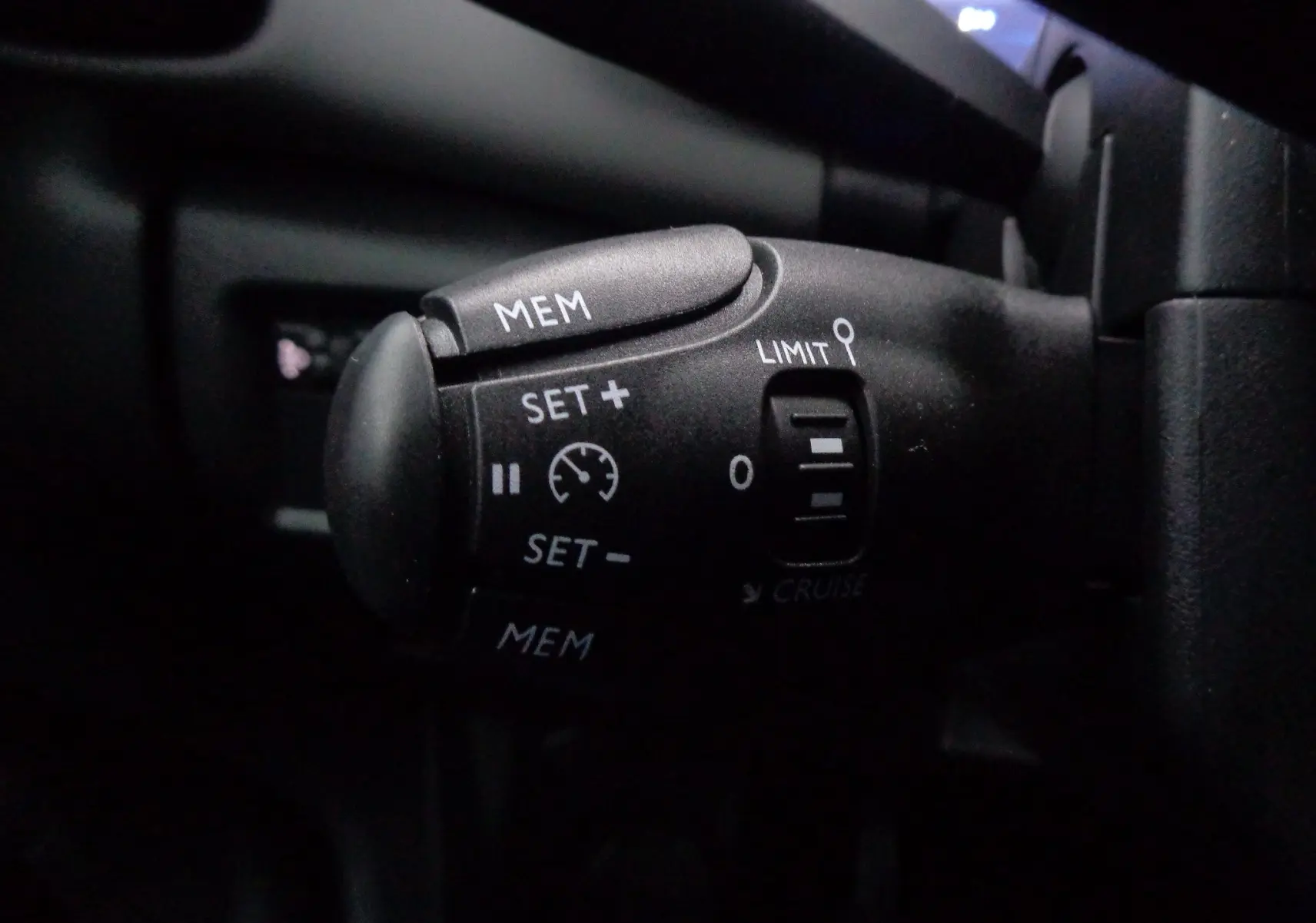 Gros plan sur la commande de régulateur de vitesse noire dans l'habitacle d'une Citroën C5 Aircross gris Artense métal.