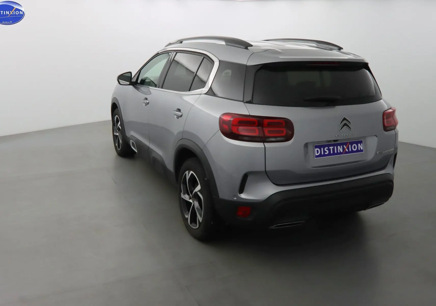 Vue 3/4 arrière d'un Citroën C5 Aircross gris Artense métallisé avec feux arrière LED et jantes bi-ton.