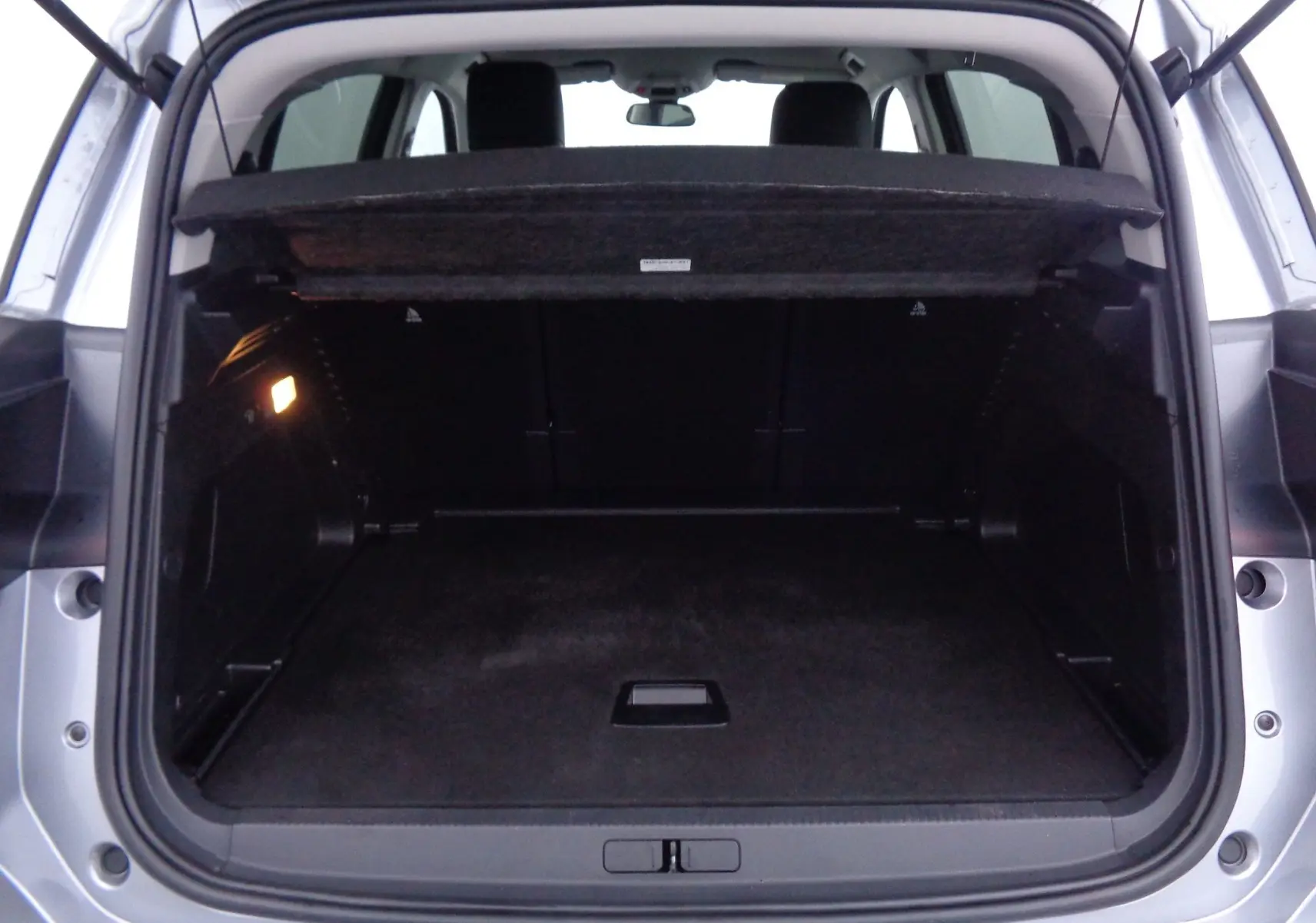 Coffre ouvert du Citroën C5 Aircross gris Artense métal, vue arrière montrant l'espace de chargement vide et la tablette cache-bagages.