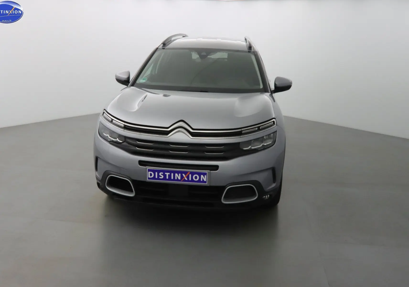 Citroën C5 Aircross gris Artense métal vu de face, mettant en valeur sa calandre distinctive et ses phares LED fins.