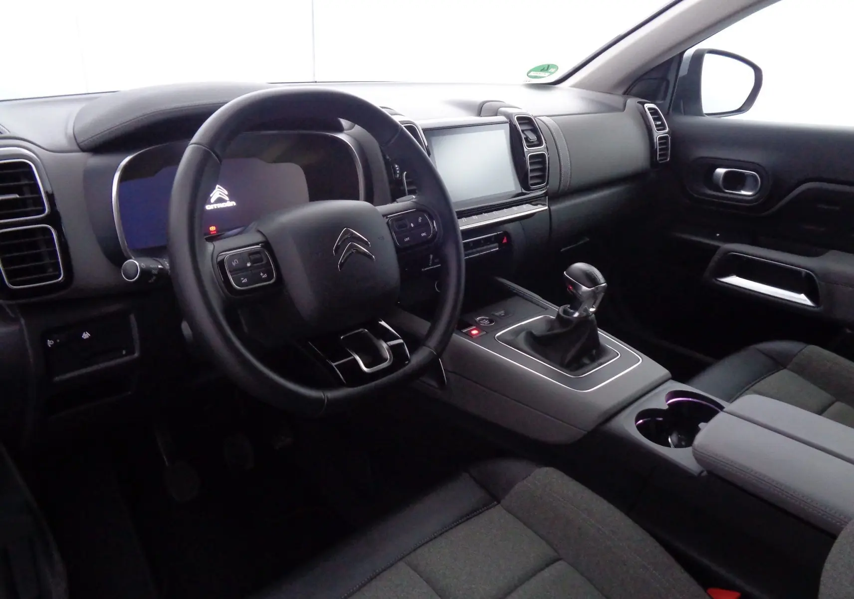 Intérieur du Citroën C5 Aircross 2021 côté conducteur, avec tableau de bord moderne et levier de vitesse manuel.